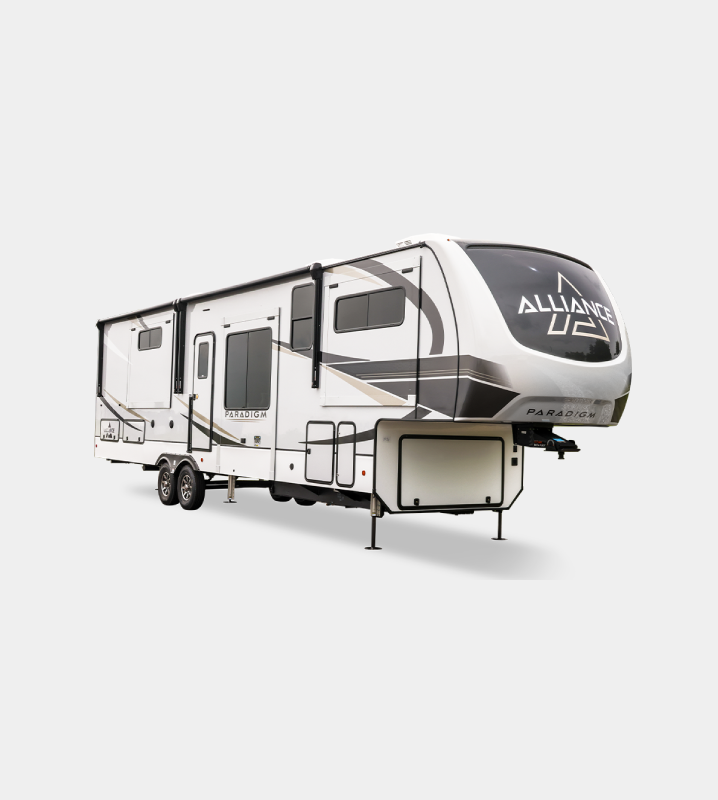 A white and black rv with a table in front of it.